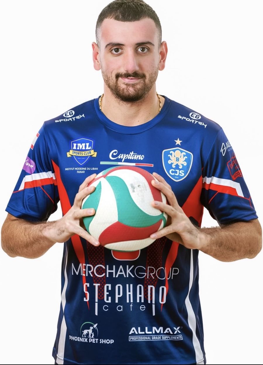 Omar Abi Karam holding a volleyball in his Batroun jersey